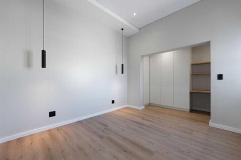 Second bedroom with open plan built in cupboards and shelves