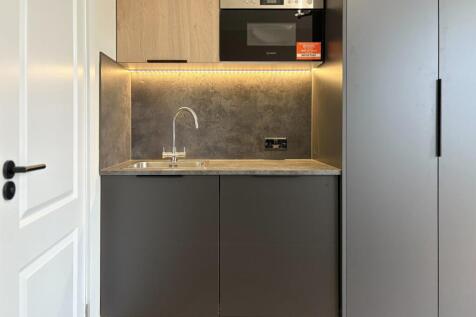 Compact modern kitchenette with integrated oven...