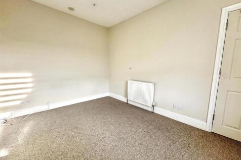 Bright and spacious neutral bedroom with carpet...