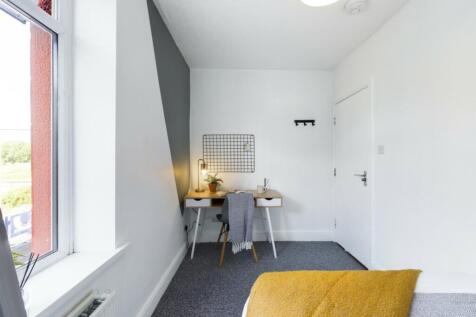 A bright and tidy double bedroom featuring a st...