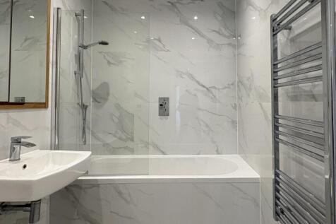 Bright contemporary bathroom with marble-effect...