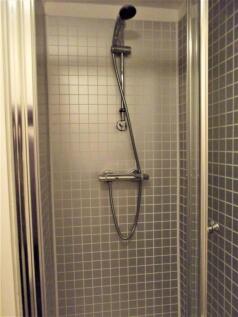 Modern tiled shower cubicle with a chrome therm...