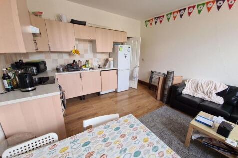 A bright and tidy living room featuring a comfo...