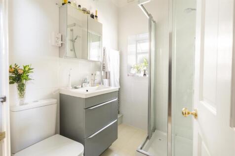 Bright modern shower room with sleek vanity uni...
