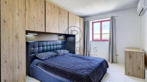 A modern bedroom featuring a bed with a blue quilt