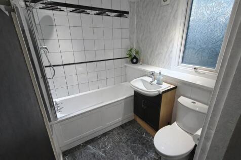 Bright tiled bathroom with bath and modern sink...