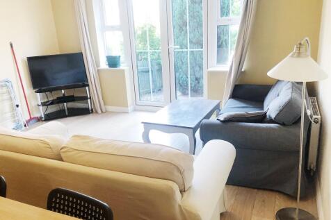 Bright, neatly furnished living room with large...