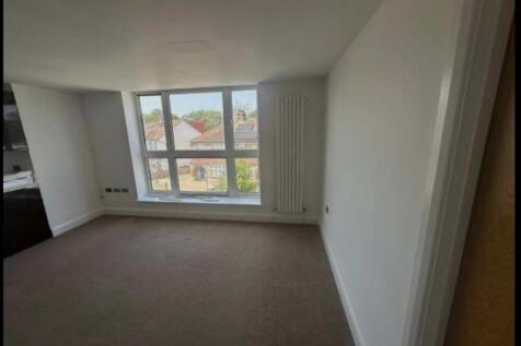 Bright, unfurnished living room with a wide win...
