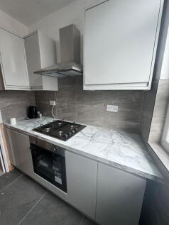 Modern fitted kitchen with marble-effect workto...