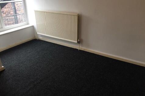 Bright, neutrally painted bedroom with a large ...