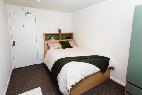 Neat, compact bedroom with a comfortable bed, b...