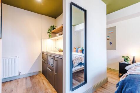 Bright, modern double bedroom with a compact ki...