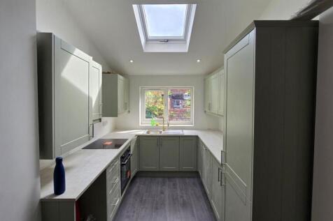 Bright modern kitchen with skylight and window...
