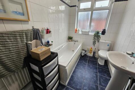 A bright and clean bathroom with a bathtub, toi...