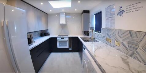 Modern fitted kitchen with marble-effect surfac...