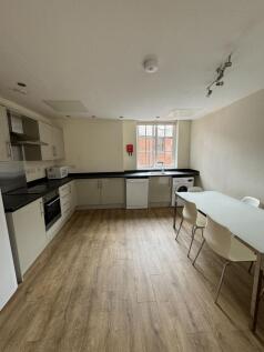 Bright modern kitchen with integrated oven, dis...