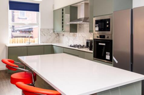 Modern kitchen featuring sleek green cabinetry,...