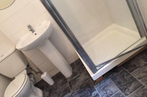 Bright, modern bathroom with a corner shower cu...