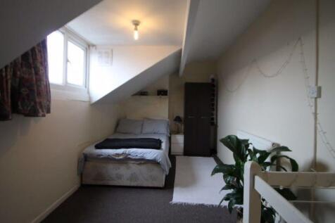 A cozy master bedroom with a double bed positio...