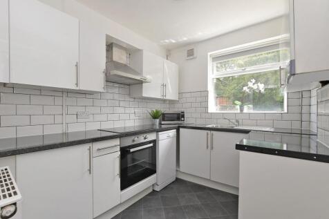 Bright, modern kitchen with glossy white cabine...
