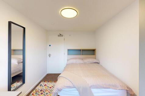 Bright, neatly arranged bedroom with a comforta...