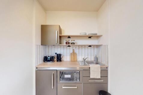 Sleek modern kitchenette with built-in applianc...