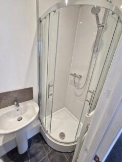 Modern bathroom featuring a compact shower encl...