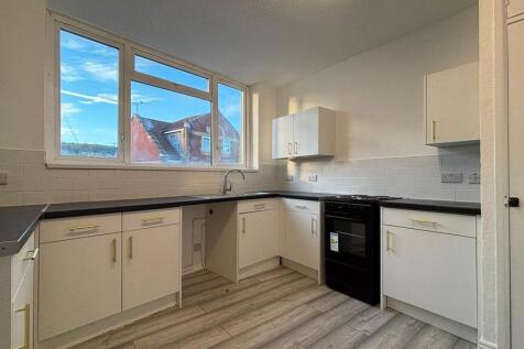 Modern bright kitchen with sleek white cabinets...