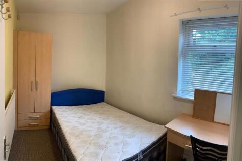 Bright, simply furnished bedroom with a single ...