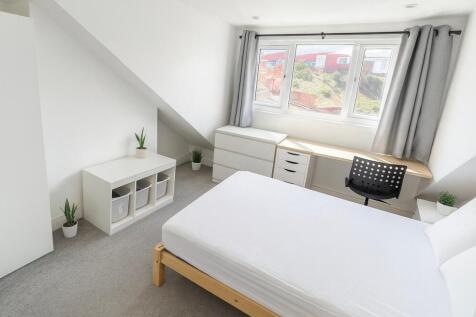 Bright, modern double bedroom with a large wind...