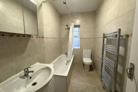Bright, modern bathroom with tiled walls and fl...