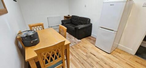 A cozy living room featuring a black sofa, wood...