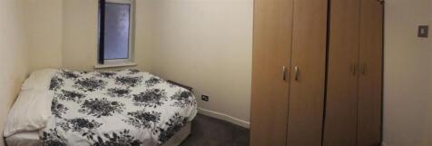 Cozy double bedroom with a patterned duvet, bui...