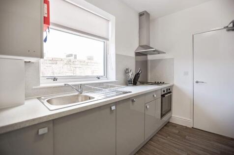Bright modern kitchen with sleek gloss cabinetr...