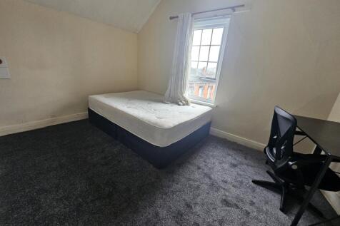 Bright, simply furnished bedroom with a double ...