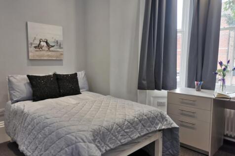 Modern bedroom with a double bed and desk space...