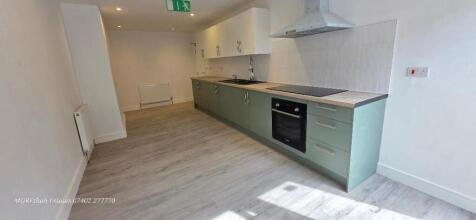 Modern kitchen with sleek sage green cabinetry...