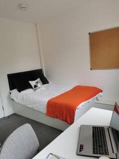 Bright, simply styled bedroom with a comfortabl...