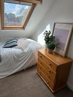 A bright and cozy bedroom with a skylight windo...
