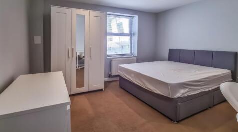 Spacious modern bedroom with ample storage spac...