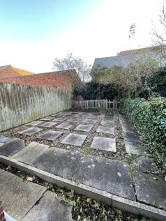 A compact garden area featuring a stone tiled g...