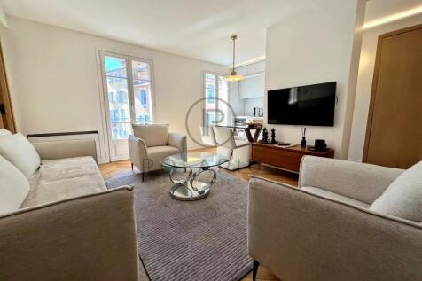 A modern, bright living room with beige sofas, a g