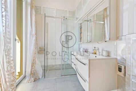 A modern bathroom with a glass shower enclosure, l