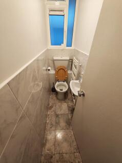 Bright cloakroom with modern marble-effect tile...