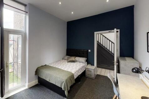 A neatly presented bedroom featuring a comforta...
