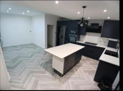 Modern kitchen with sleek island and wood floor...