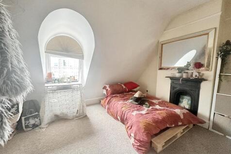 Charming bedroom with unique arched window...