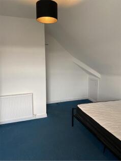 A spacious double bedroom with a cozy atmospher...