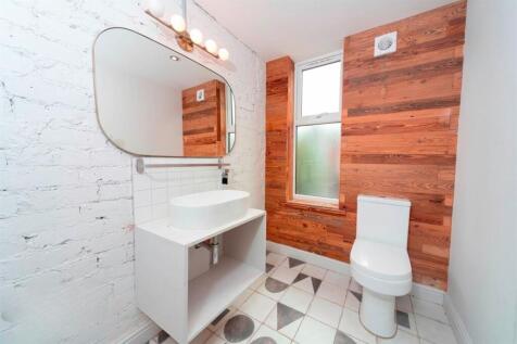 Modern bathroom with wood-paneled feature wall...
