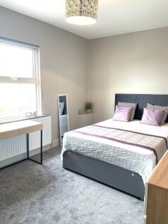 Bright and welcoming double bedroom featuring a...